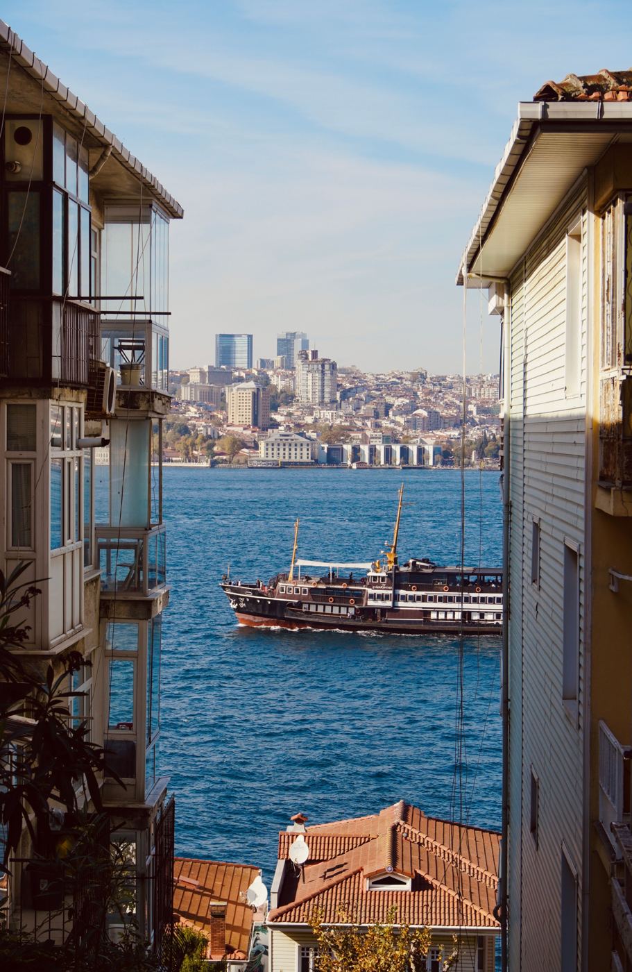 A Bosphorus ferry crossing between Europe and Asia, seen between old Istanbul houses