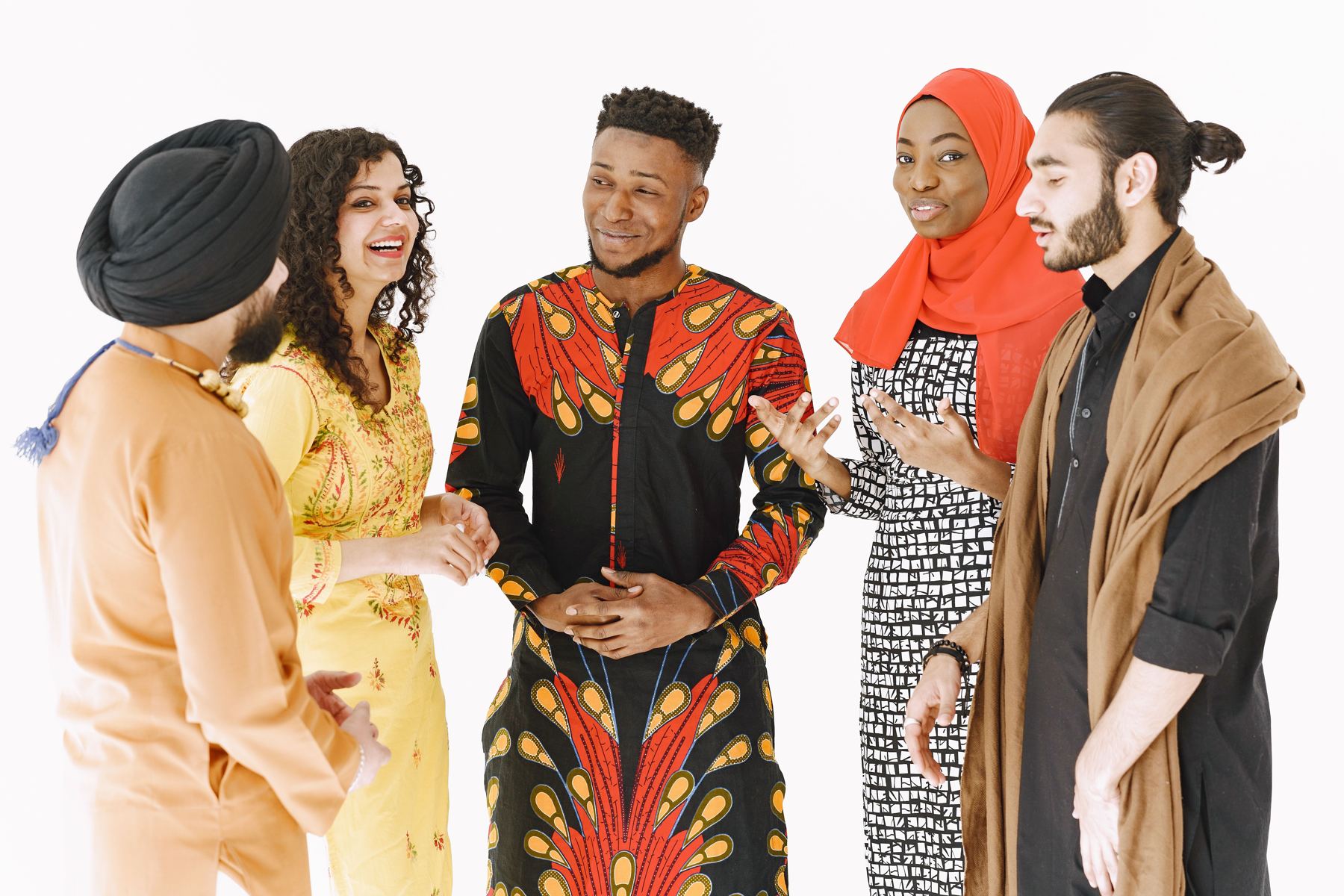 Young people in traditional clothing from different cultures talking and laughing together